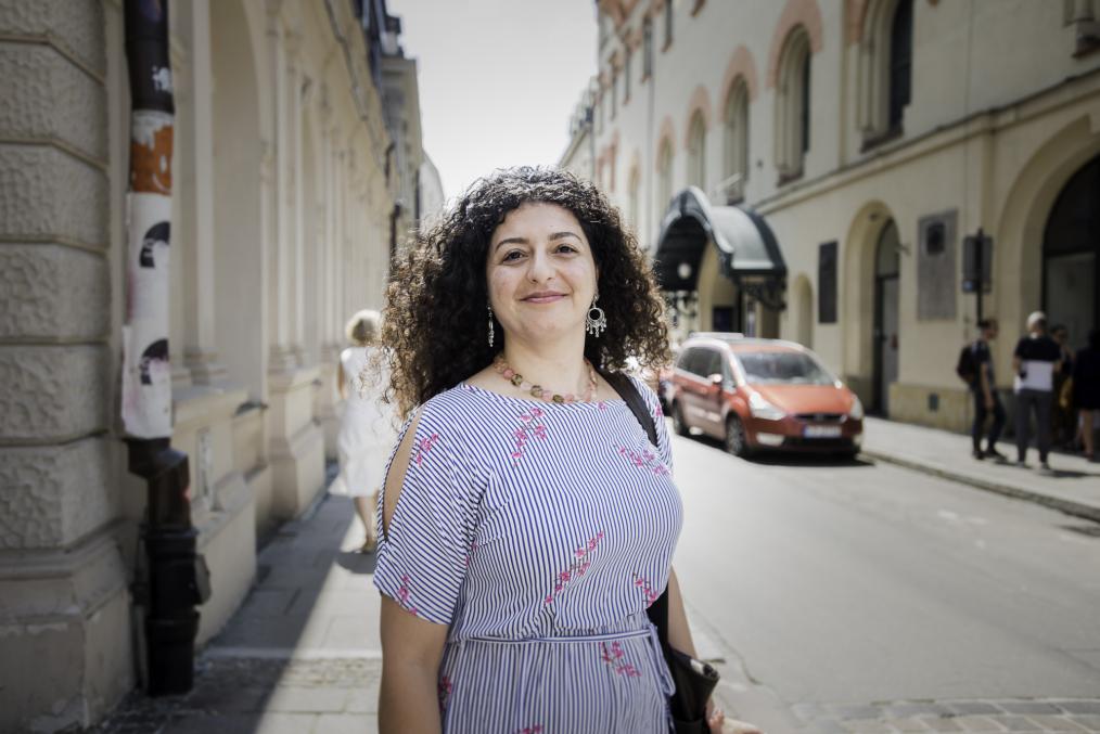 portrait picture of UNESCO resident Kholoud Charaf. A woman is standing in the sun in the street in Krakow